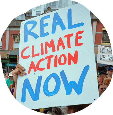 Man holding Real Climate Action Now Sign